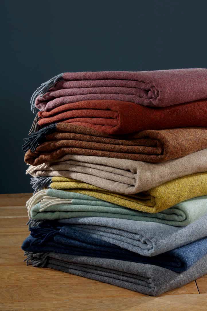 Пледы Biederlack CASHMERE сложены стопкой — виден весь ряд расцветок коллекции, включая сине-серую (blau-grau)