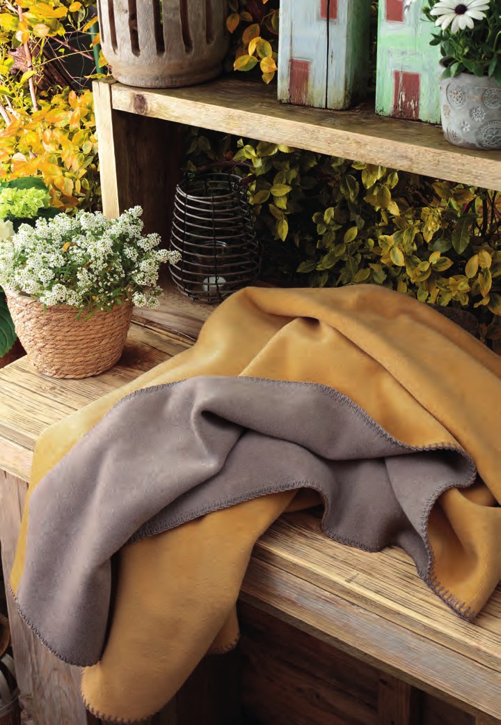 Плед Biederlack HONEY TAUPE сложен вчетверо: медово-жёлтая лицевая сторона, серо-коричневая изнанка, край обмётан