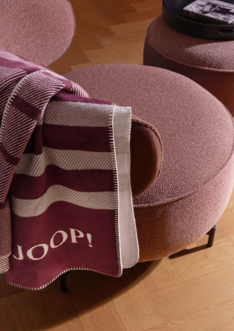 Плед JOOP! SHUTTER ROUGE, бордовый в бело-бордовую полосу, наброшен на кресло, вышитый логотип JOOP!