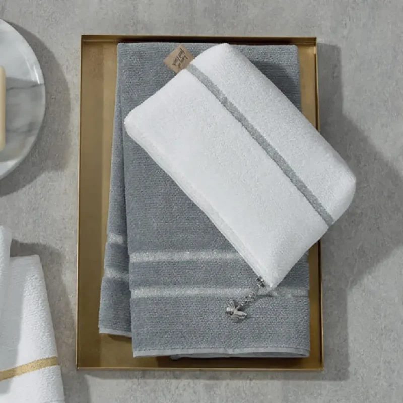 Косметичка Feiler LA GLAMOUR WEIB-SILVER, серая с белой полосой, на золотом подносе рядом с полотенцем